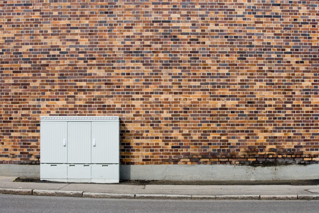 Ein Verteilerkasten steht vor eine Hauswand aus Backsteinen © Deutsche Telekom