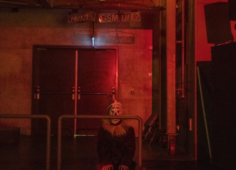 Szene aus der Vorstellung "Der Clowns-Kongress": Ein Clown sitzt auf einer Treppe hinter der Bühne