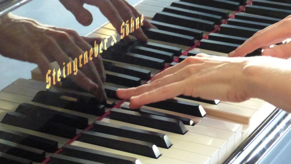 Hände spielen auf einer Klaviertastatur