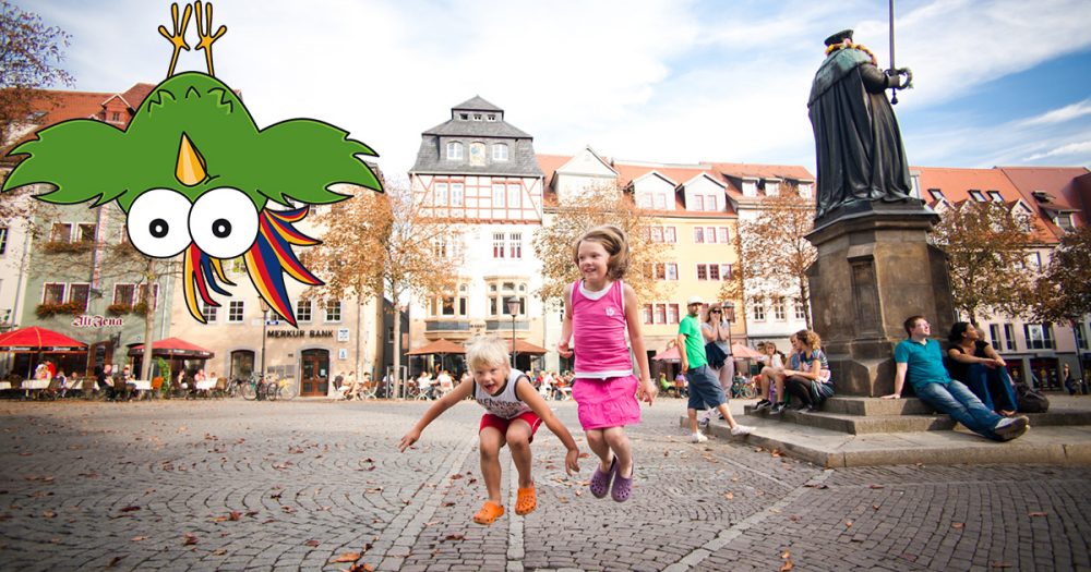 Spielende Kinder auf dem Marktplatz Jena, Comicfigur Paradiesvogel Adam kopfüber in der Ecke