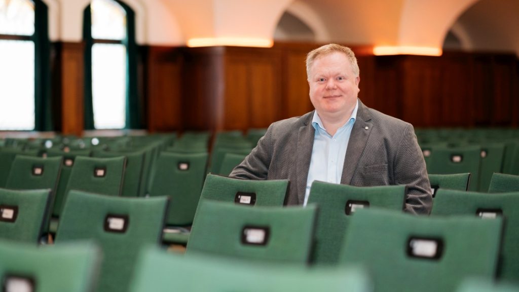 Alexander Richter sitzt in den Zuschauerreihen des Ernst-Abbe-Saals im Volkshaus Jena