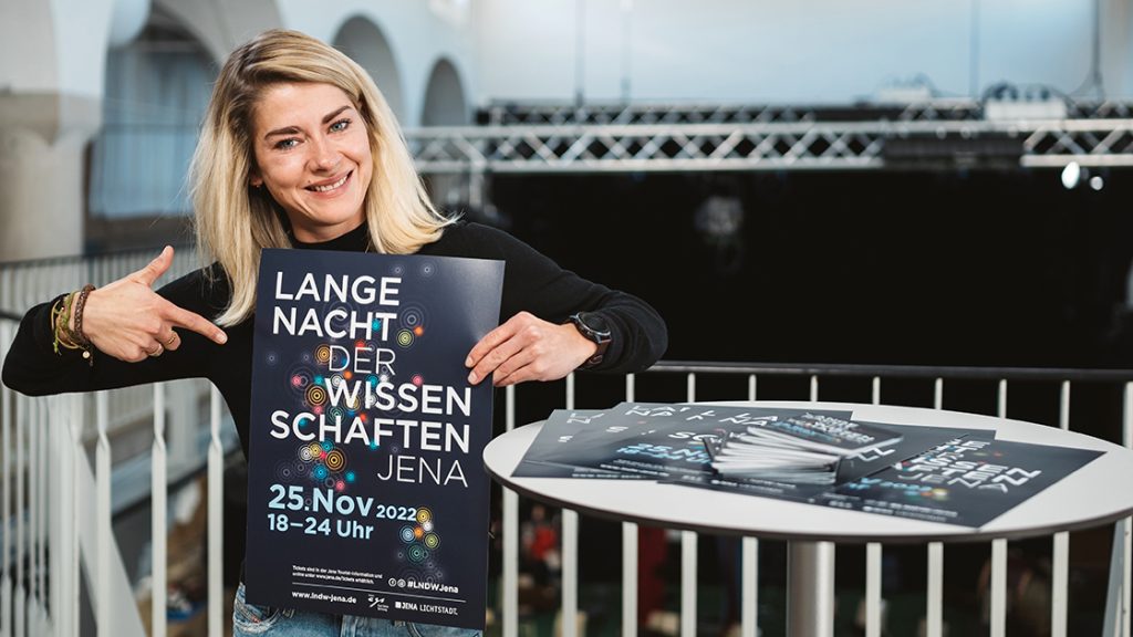 Anna Fuhlbrügge zeigt das Plakat der LNDW Jena
