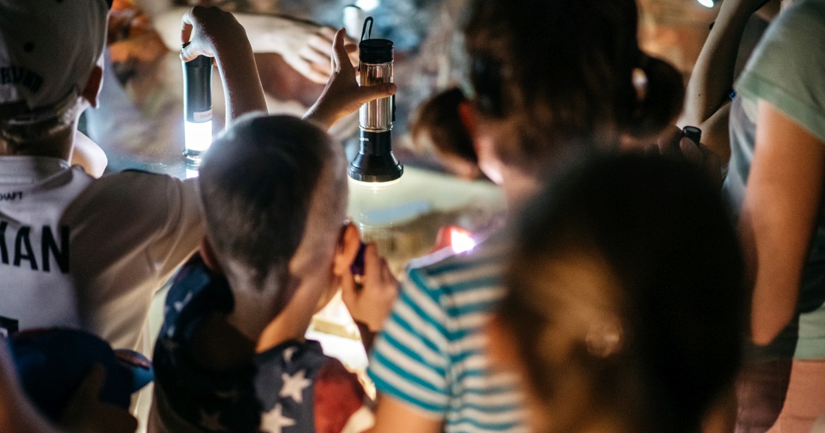 Kinder mit Taschenlampen an einer Vitrine in den Städtischen Museen Jena