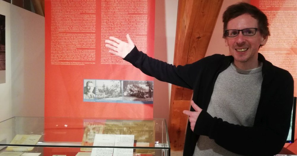 Christian Hermann zeigt auf Schautafeln im Stadtmuseum Jena