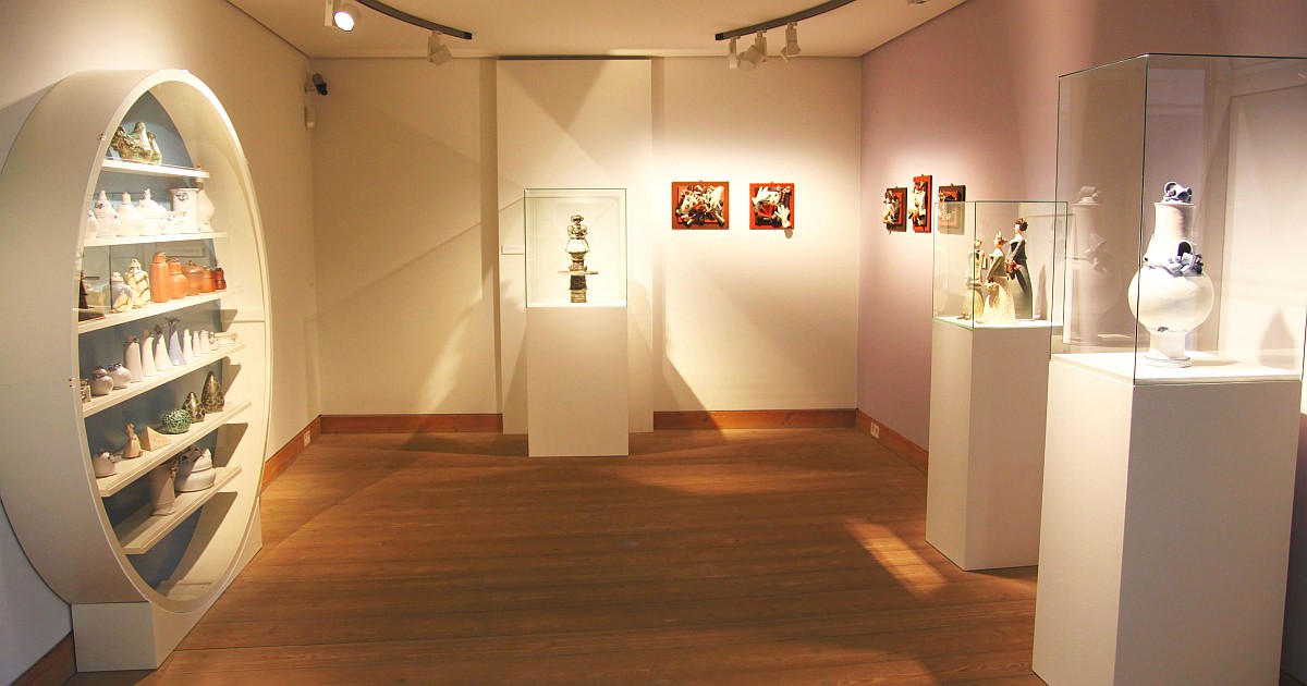 Blick in die Ausstellung von Ulli Wittich-Großkurth im Stadtmuseum Jena mit verschiedenen Keramikarbeiten in Vitrinen und Regalen, z. B. Vasen und Figuren