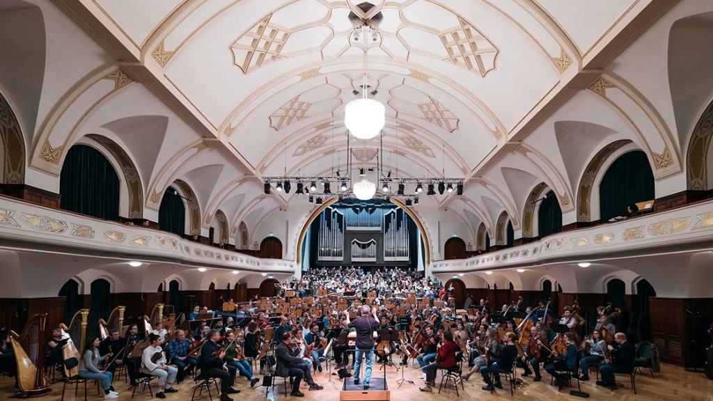 Blick in den Sall des Volkshauses Jena, in dem 400 Musiker:innen unter Leitung von Simon Gaudenz für das Jubilöumskonzert der Jenaer Philharmonie proben