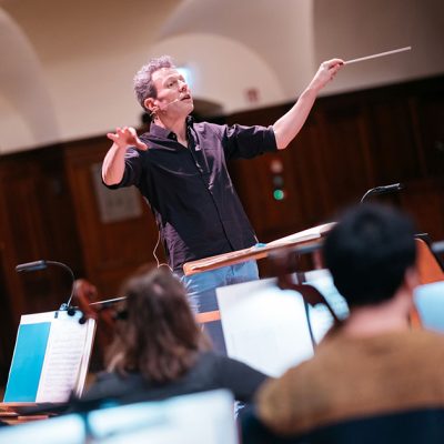 Simon Gaudenz dirigiert die Probe der Jenaer Philharmonie für das Jubiläumskonzert