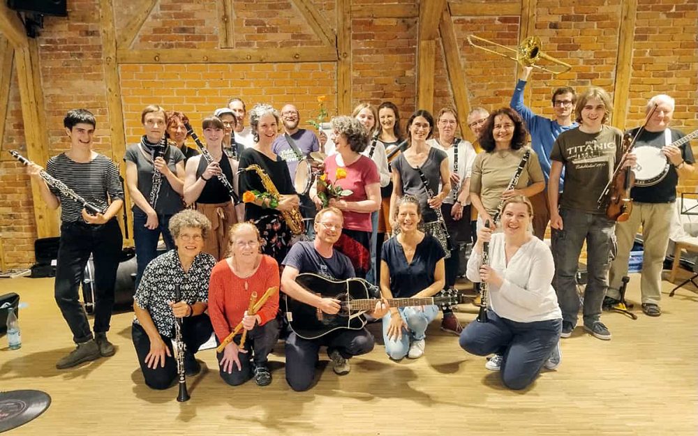 Gruppenfoto Klezmerworkshop, ca. 20 freudige Personen mit Instrumenten