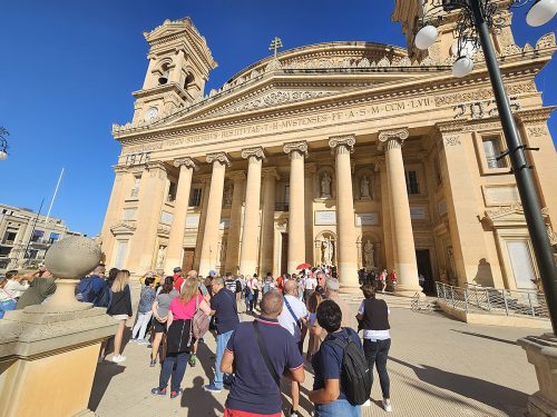 Eine Kirche auf Malta von außen, viele Besucher:innen schauen sie sich an: Rotunda von Mosta