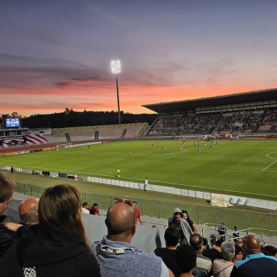 Ein Fußballstadium auf Malta, ein Spiel ist im Gang, viele Zuschauer:innen