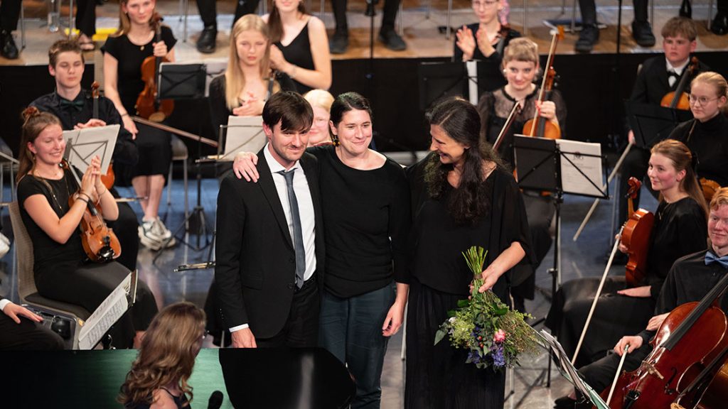 Musiker:innen beim Applaus auf der Bühne beim Abschlusskonzert im Volksbad Jena