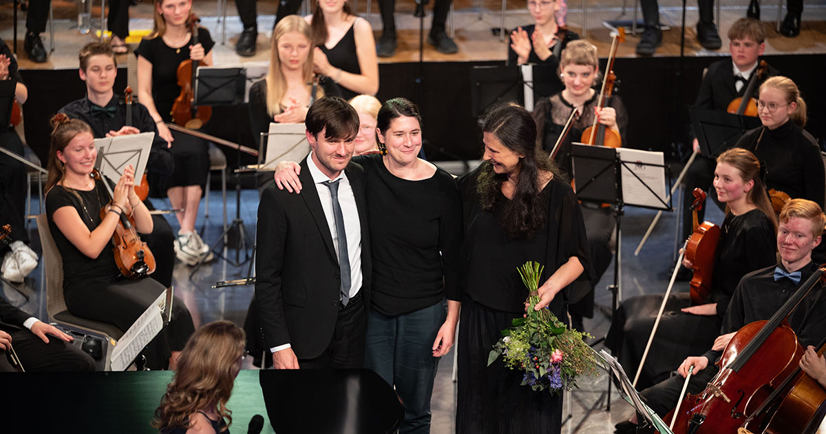 Musiker:innen beim Applaus auf der Bühne beim Abschlusskonzert im Volksbad Jena