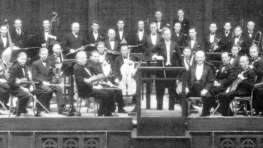 Historische Fotografie von 1934 von Musikern in Frack und Fliege auf der Bühne