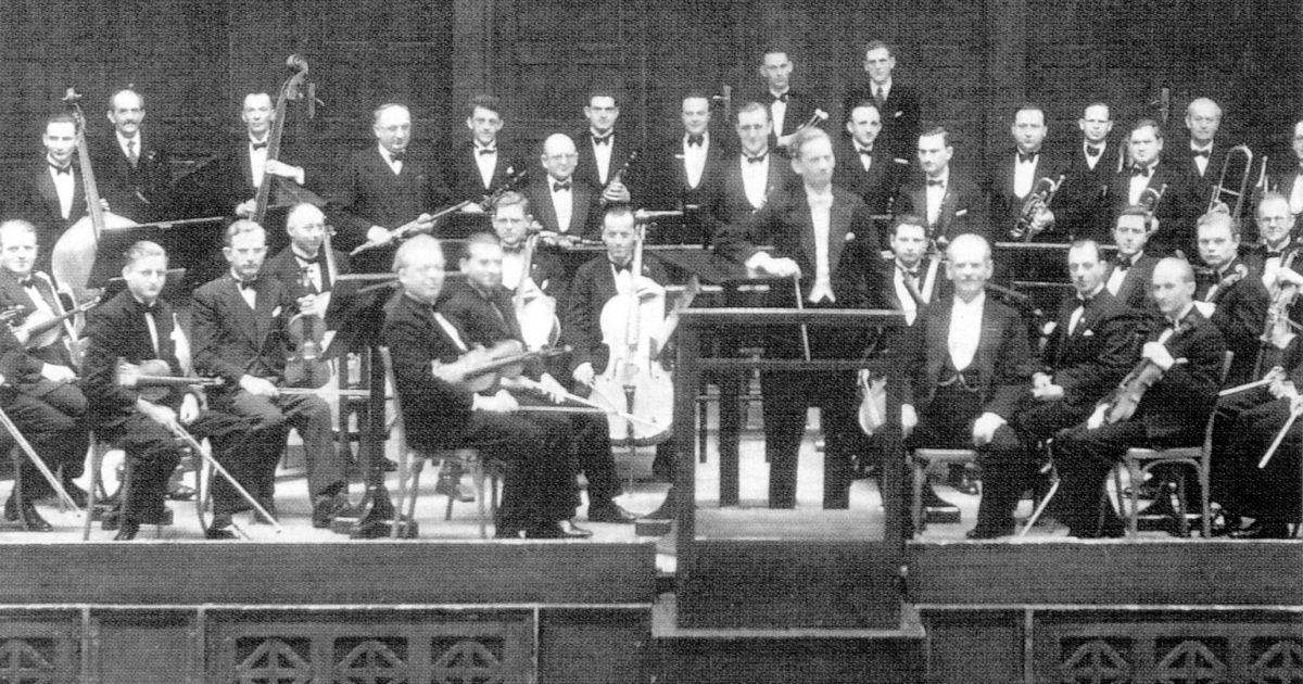 Historische Fotografie von 1934 von Musikern in Frack und Fliege auf der Bühne