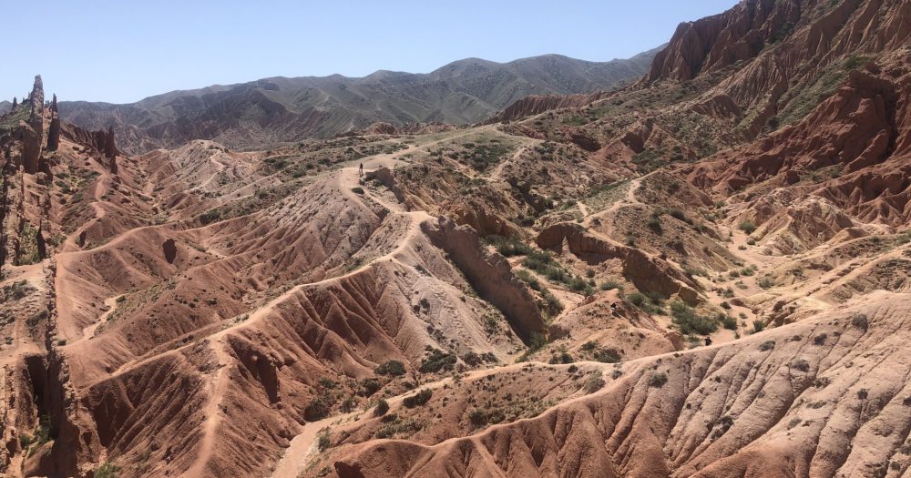 Eine marähnliche Landschaft mit rötlichen Hügeln in Kirgistan.