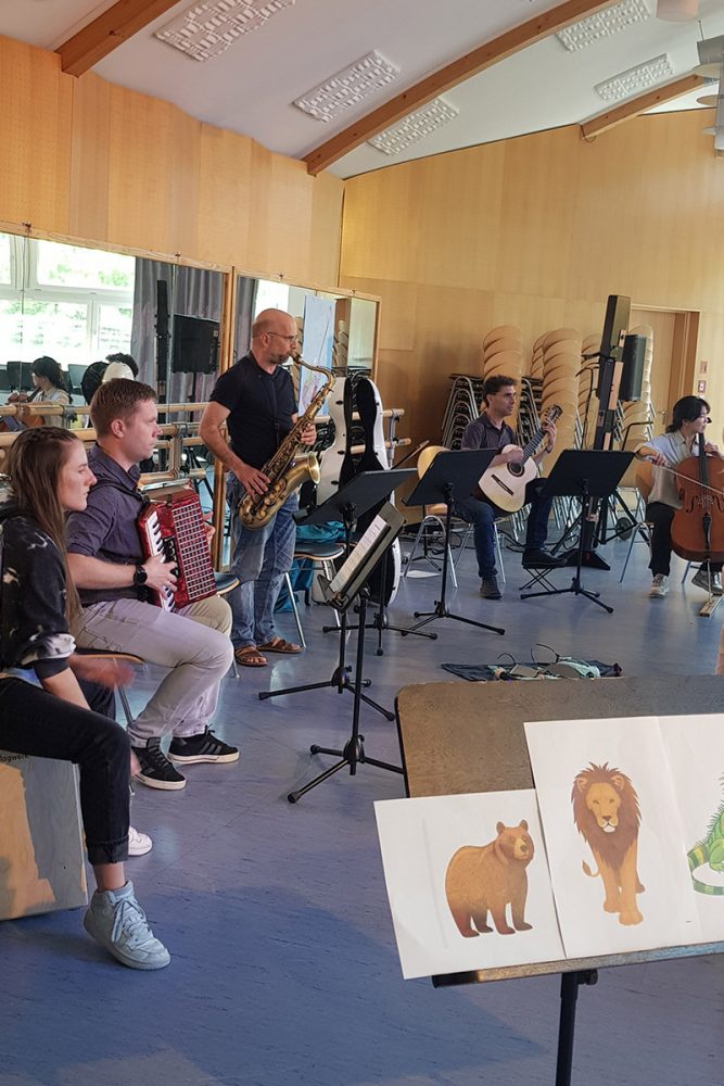 Schüler:innen mit verschiedenen Instrumenten bei einem Konzert