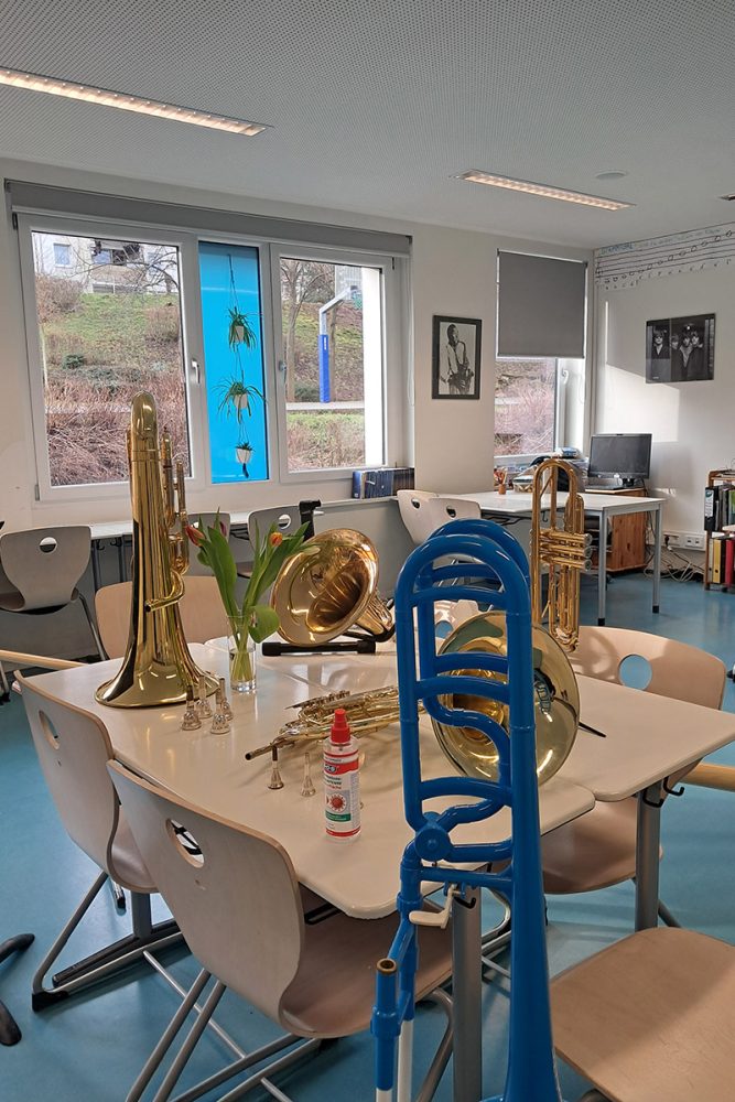 Bild mit verschiedenen Blasinstrumenten in einem Klassenzimmer