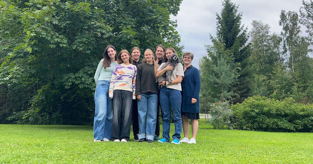 Schülerinnen der Musik- und Kunstschule Jena posieren mit ihrer Gastfamilie in deren Garten