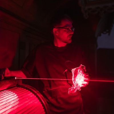 Lichtkünstler Robert Seidel formt Gebilde aus einem roten Laserstrahl
