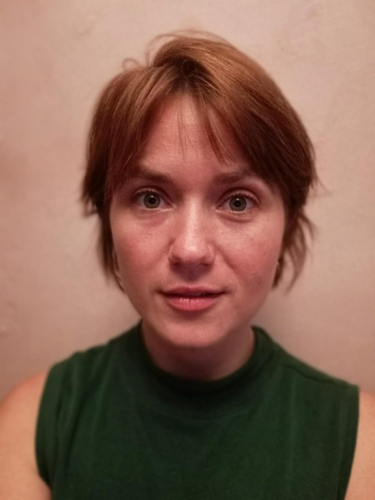 Ein Porträt einer Frau mit kurzem rötlichen Haar.