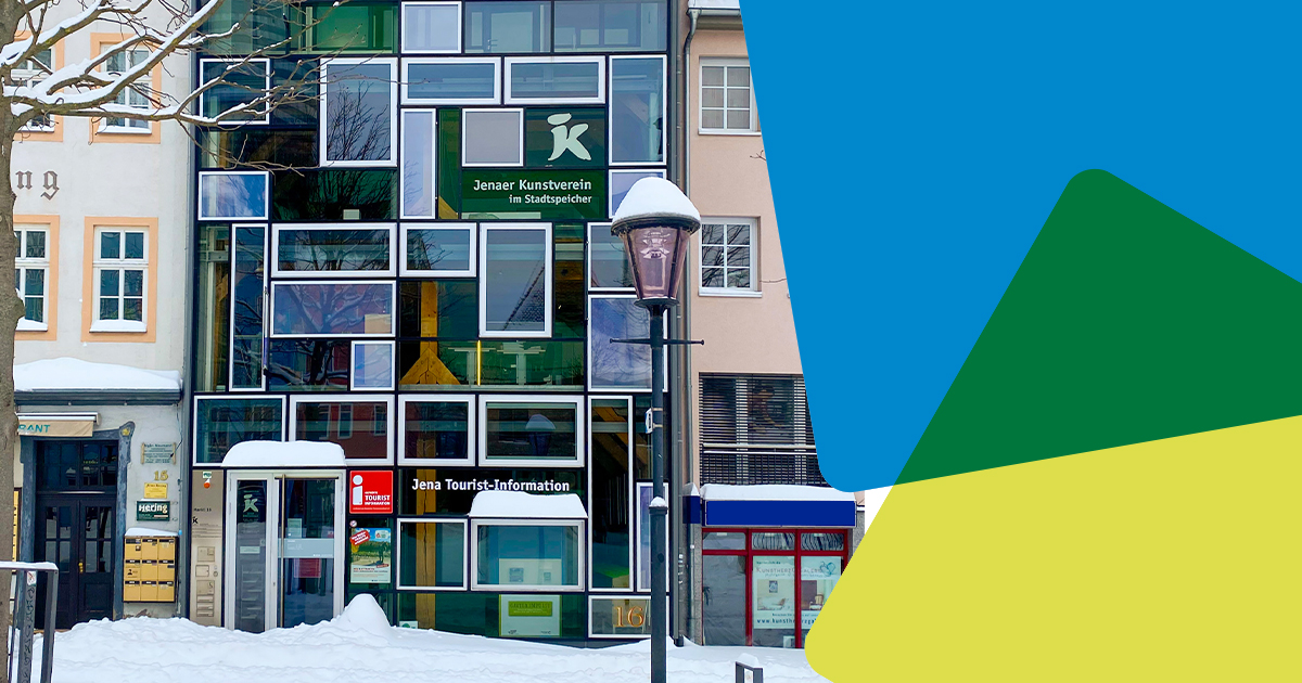 Blick auf die verschneite Jena Tourist-Information mit JenaKultur-CD-Würfeln am rechten Rand