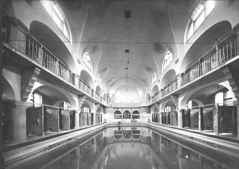 Historische Aufnahme in Schwarz-Weiß von der leeren Badehalle des Volksbades Jena mit Schwimmbecken