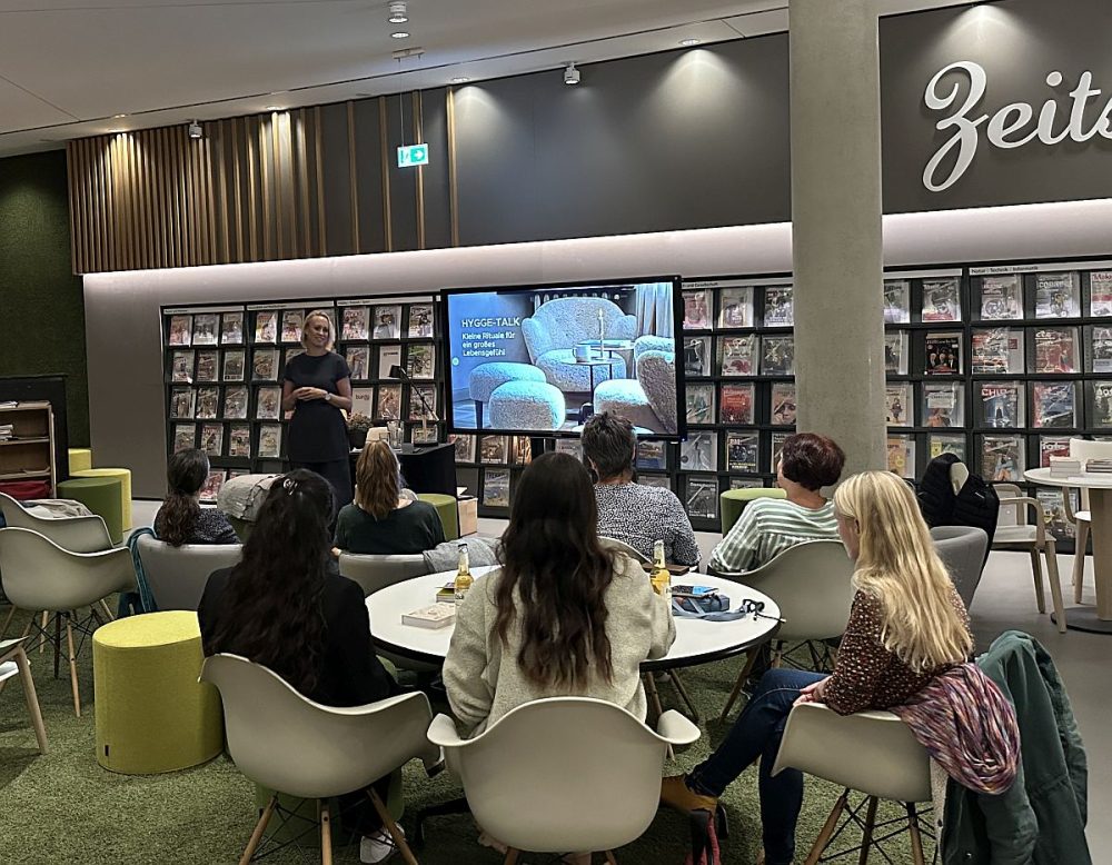 Hygge Talk in der EAB Jena, einige Zuschauerinnen sitzen im Lesesalon und hören gespannt dem Talk zu