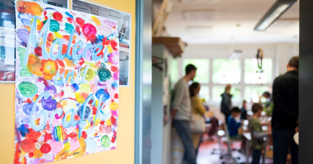 zu sehen ist der Eingang in ein Zimmer. links ist die offenstehende Tur, an der ein buntes Bild mit der Aufschrift "Malerei und Grafik" steht.