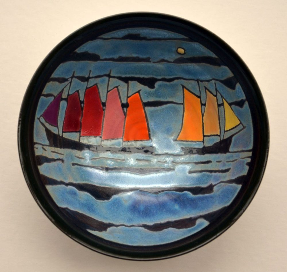 Die Bildschale ist rund und zeigt Wellen mit Schiffen. Die Segel der Schiffe sind rot, geld, orange