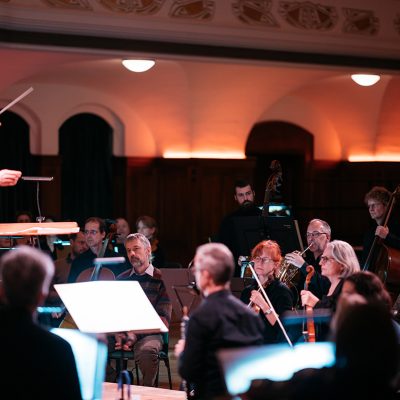 Blick ins Volkshaus Jena zur Aufführung von 360° der Jenaer Philharmonie, Simon Gaudenz dirigiert, ein paar Musiker:innen sind zu sehen