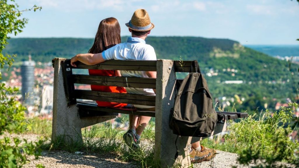 2 Menschen sitzen auf einer Bank und schauen über Jena