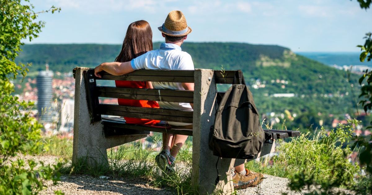2 Menschen sitzen auf einer Bank und schauen über Jena