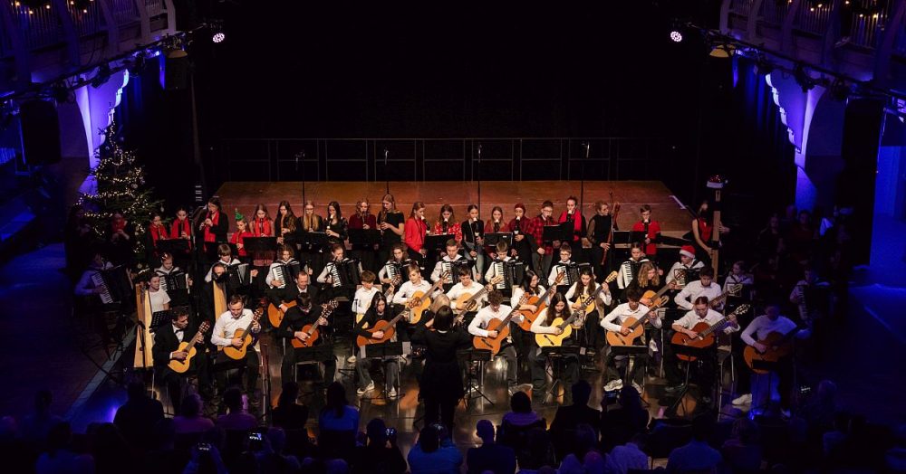 Adventskonzert der MKS Jena 2024 im Volksbad Jena: Viele Akkordeonschüler:innen sitzen auf der Bühne, dazu viele Gitarrenschüler:innen
