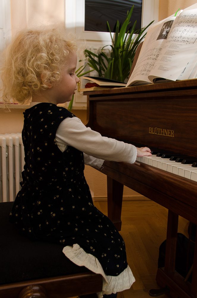 Elsa-Johanna Staemmler sitzt als Kind an einem Klavier