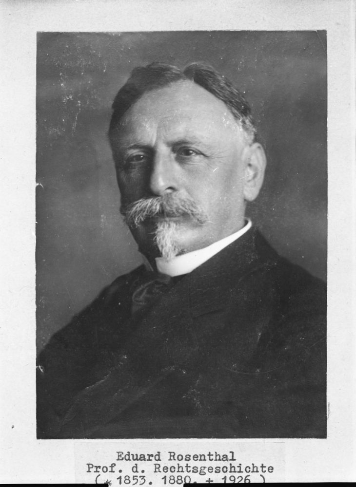 Das Portrait eines Mannes. Er trägt ein schwarzes Hemd und einen markanten Schnurrbart.
