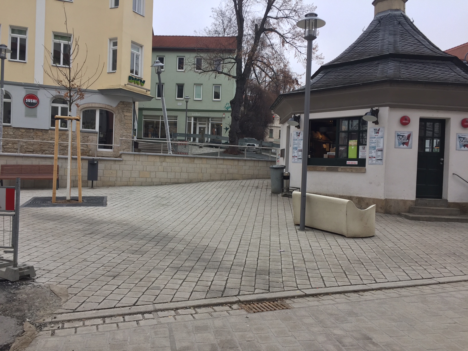 Zu sehen ist ein Teil des bereits fertig gestellten Johannisplatz / Ecke Imbiss.